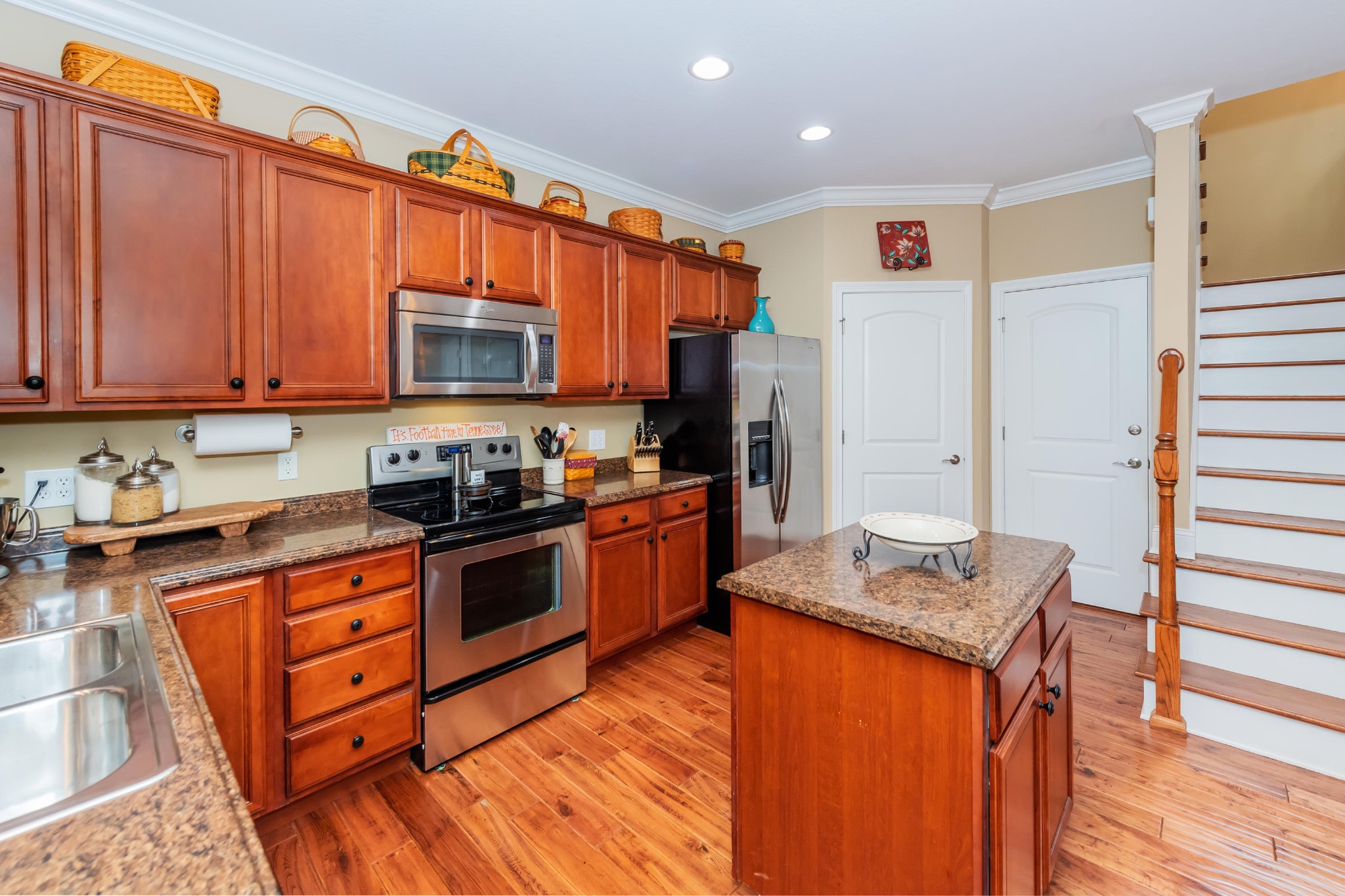 1833 Duncan Road, Unit 104 Knoxville, TN 37919 - Photo 7 of 36 a kitchen with stainless steel appliances granite countertop a stove top oven a refrigerator a sink and dishwasher with wooden floor