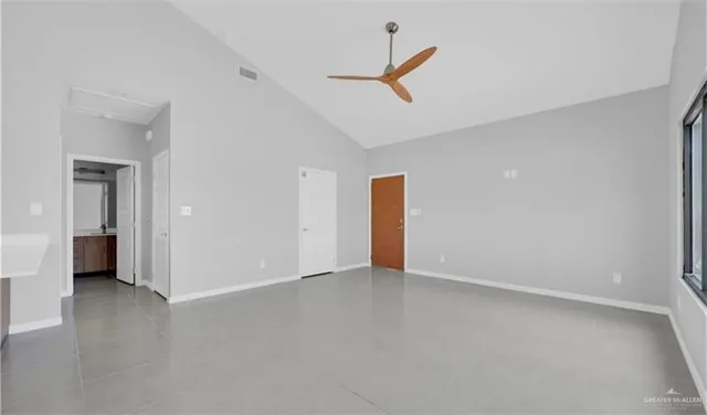 an empty room with closet and a ceiling fan