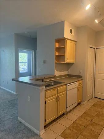 a kitchen with granite countertop cabinets stainless steel appliances a sink and a window