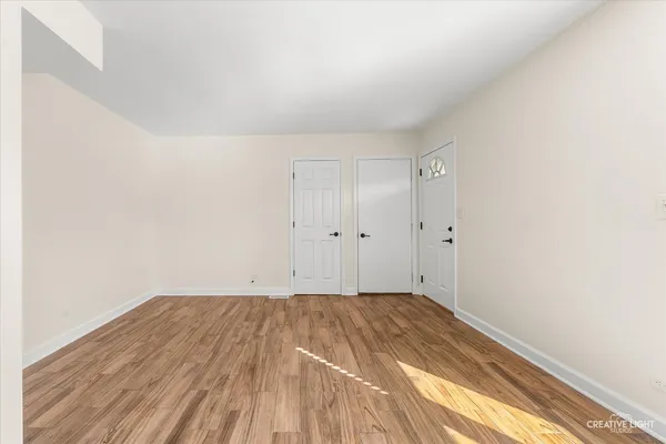 a view of empty room with wooden floor