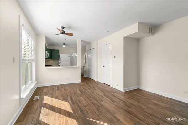 a view of an empty room with window and wooden floor