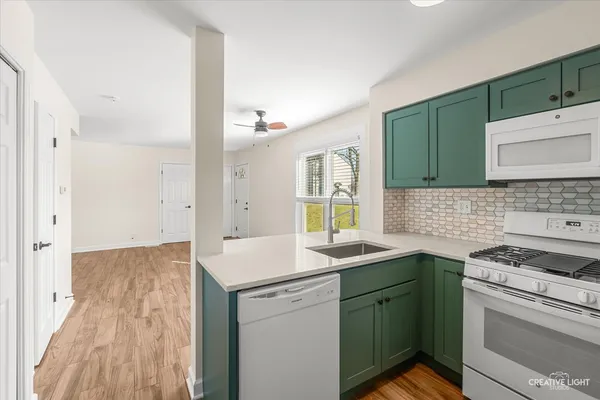 a kitchen with a sink cabinets and wooden floor