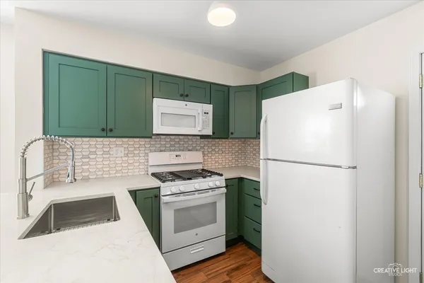 a white refrigerator freezer and a stove sitting inside of a kitchen