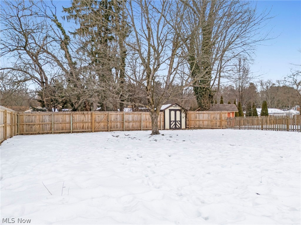 3517 26th Street Northwest Canton, OH 44708 - Photo 3 of 22 Yard covered in snow with a storage unit and a fenced backyard