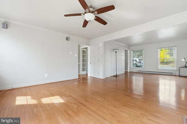a living room with stainless steel appliances kitchen island granite countertop wooden floor and a view of kitchen
