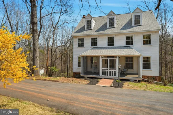 a view of a white house with a large windows next to a road