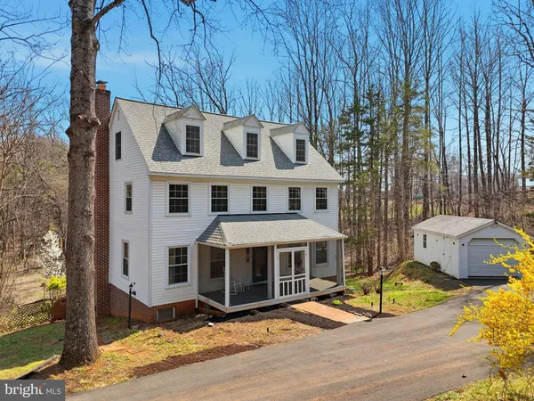 a view of a white house with large windows and a table and chairs