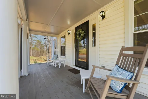 a view of a patio with table and chairs with wooden floor and fence