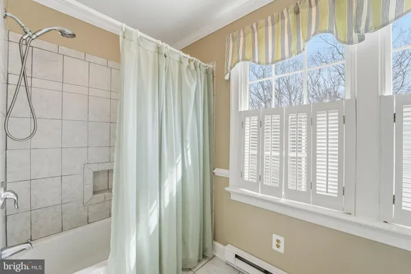 an empty room with wooden floor chandelier fan and windows