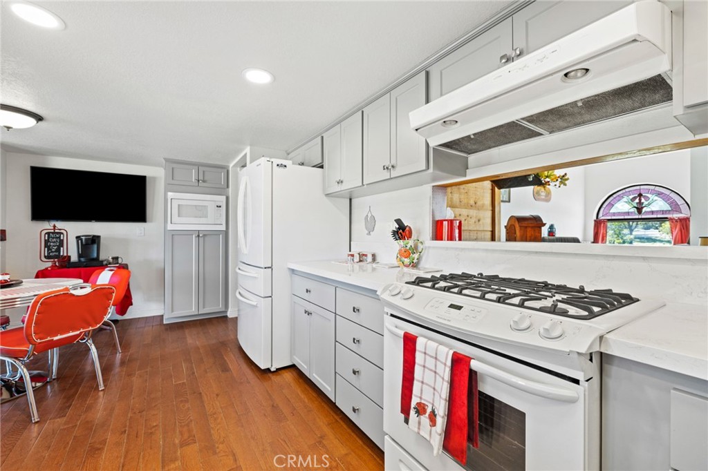 61116 Devils Ladder Road Mountain Center, CA 92561 - Photo 24 of 74 a kitchen with stainless steel appliances granite countertop a stove a sink dishwasher and a dining table with wooden floor