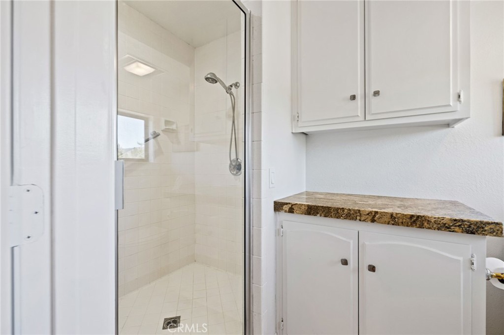 61116 Devils Ladder Road Mountain Center, CA 92561 - Photo 42 of 74 a bath room with a granite countertop shower and cabinets
