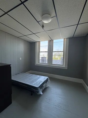 a view of an empty room with a fireplace and a window