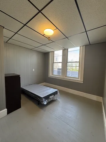 a bed sitting in a bedroom next to a window