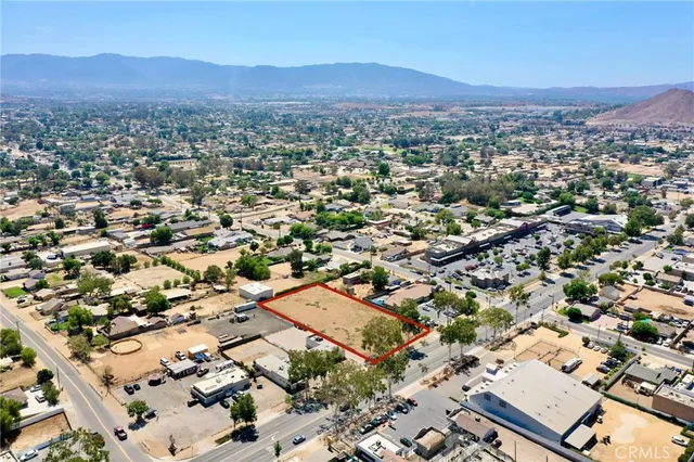an aerial view of residential house with parking and trees