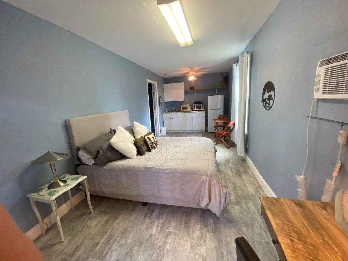 2141 B Road, Unit STUDIO Loxahatchee Groves, FL 33470 - Photo 3 of 6 a bedroom with a bed and wooden floor