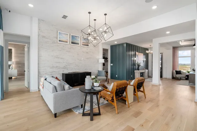 a living room with furniture a fireplace and a chandelier