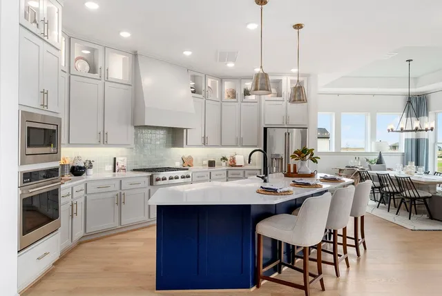 a large kitchen with kitchen island a dining table and chairs
