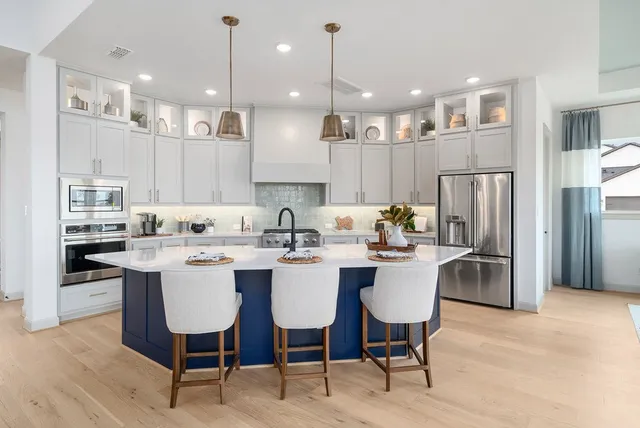 a kitchen with a dining table chairs refrigerator and cabinets