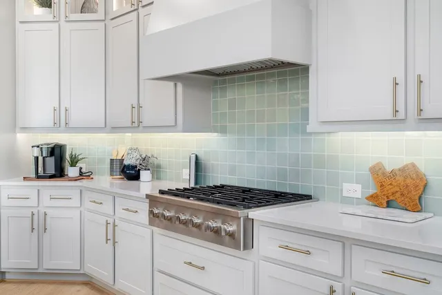 a kitchen with white cabinets and appliances