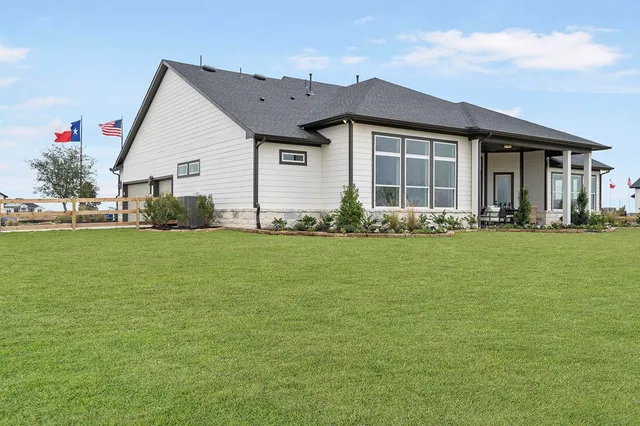 a front view of a house with a yard and outdoor seating