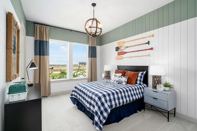 a bedroom with a bed chandelier and a window