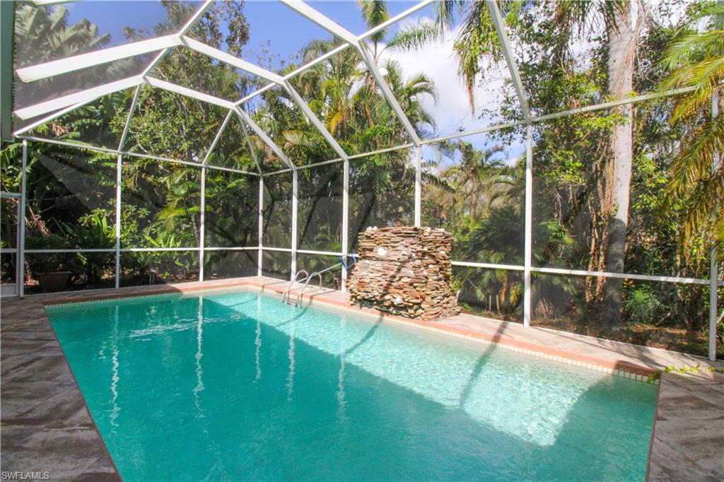 627 Soliel Drive Naples, FL 34110 - Photo 1 of 45 a view of a backyard with table and chairs and wooden fence