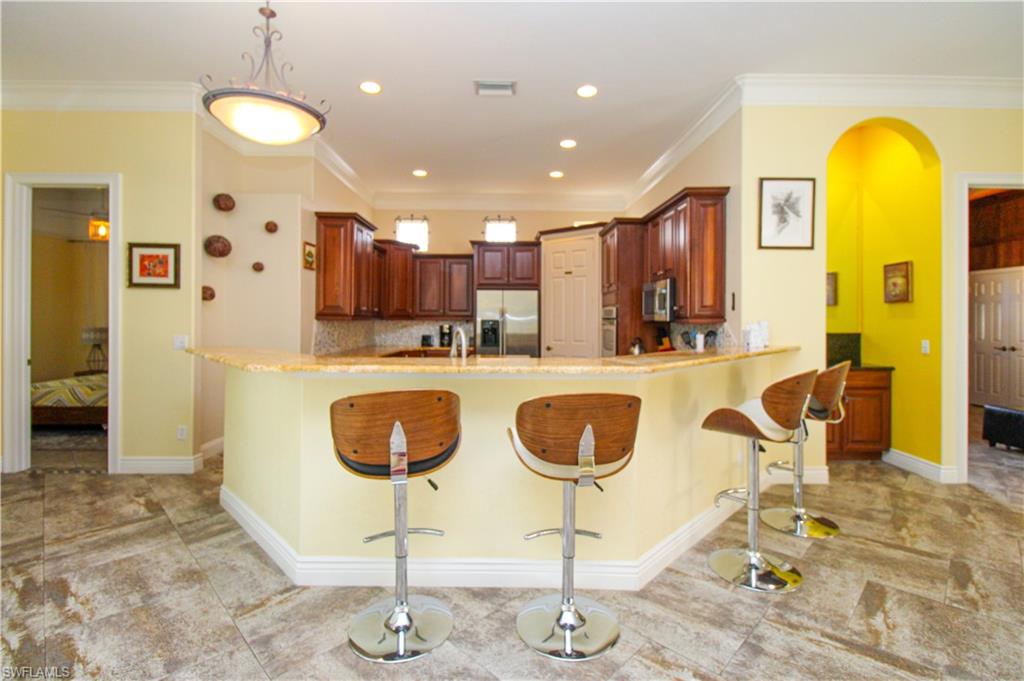 627 Soliel Drive Naples, FL 34110 - Photo 12 of 45 a kitchen with dining table and chairs