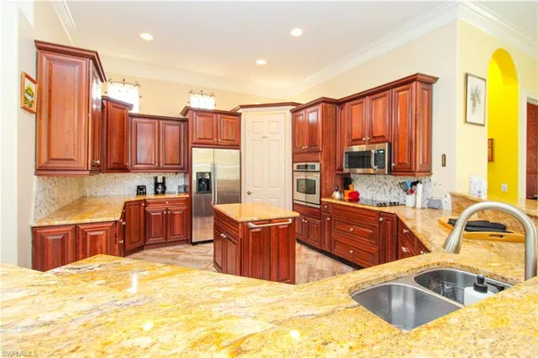 a kitchen with stainless steel appliances granite countertop a sink stove and refrigerator