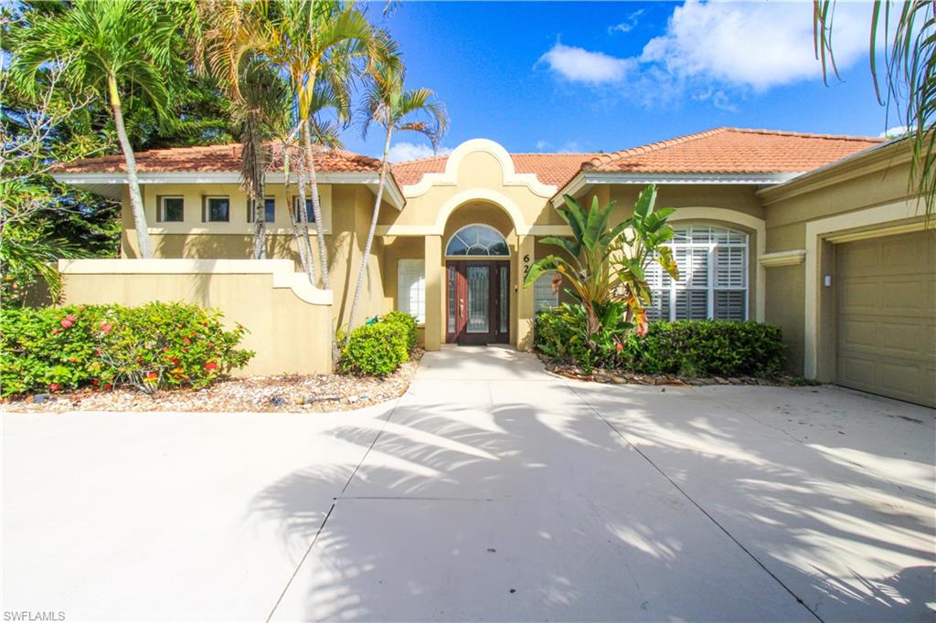 627 Soliel Drive Naples, FL 34110 - Photo 2 of 45 a front view of a multi story residential apartment building with a yard
