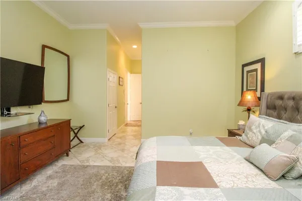 a bedroom with a bed and a flat tv screen on wall