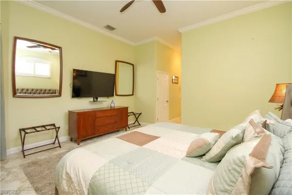 a bedroom with a bed and a flat tv screen on dresser