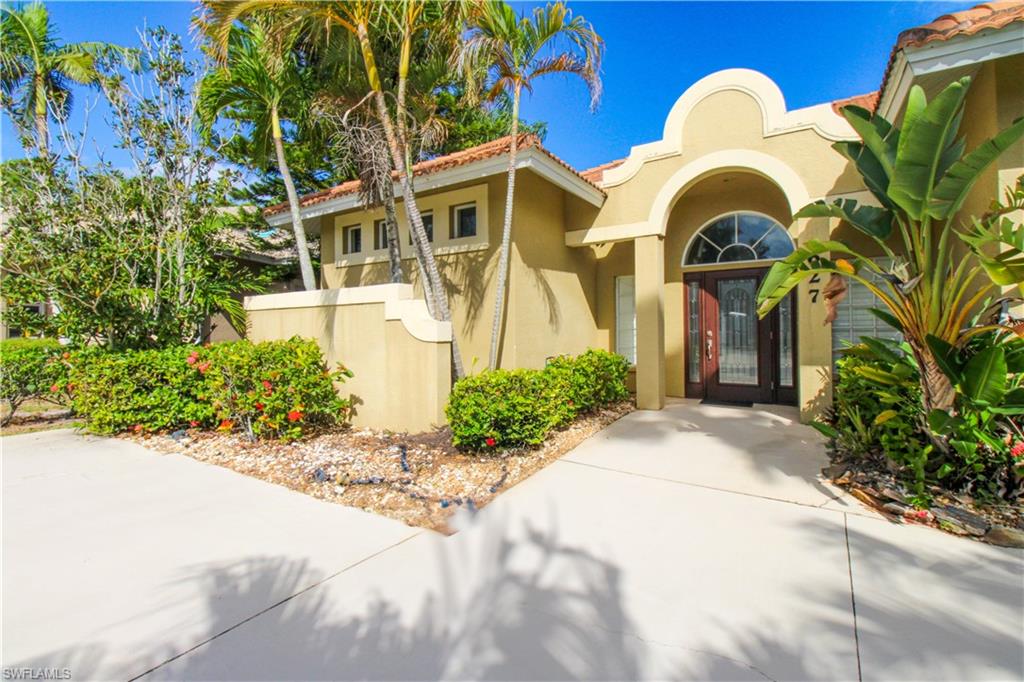 627 Soliel Drive Naples, FL 34110 - Photo 3 of 45 a front view of a house with a garden