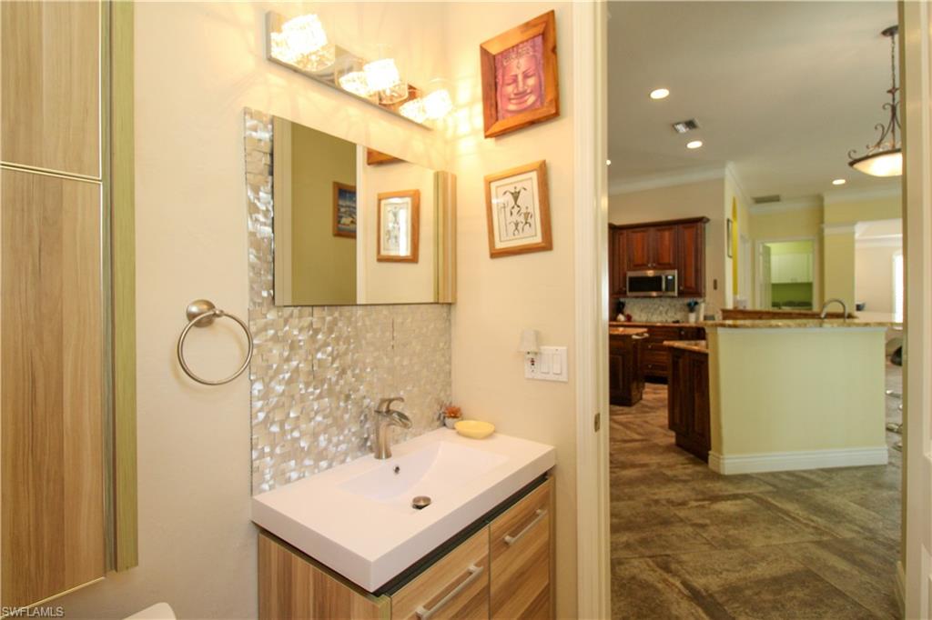 627 Soliel Drive Naples, FL 34110 - Photo 33 of 45 a bathroom with a sink a mirror and a shower