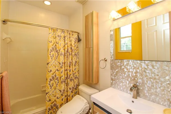 a bathroom with a sink a toilet and shower curtain