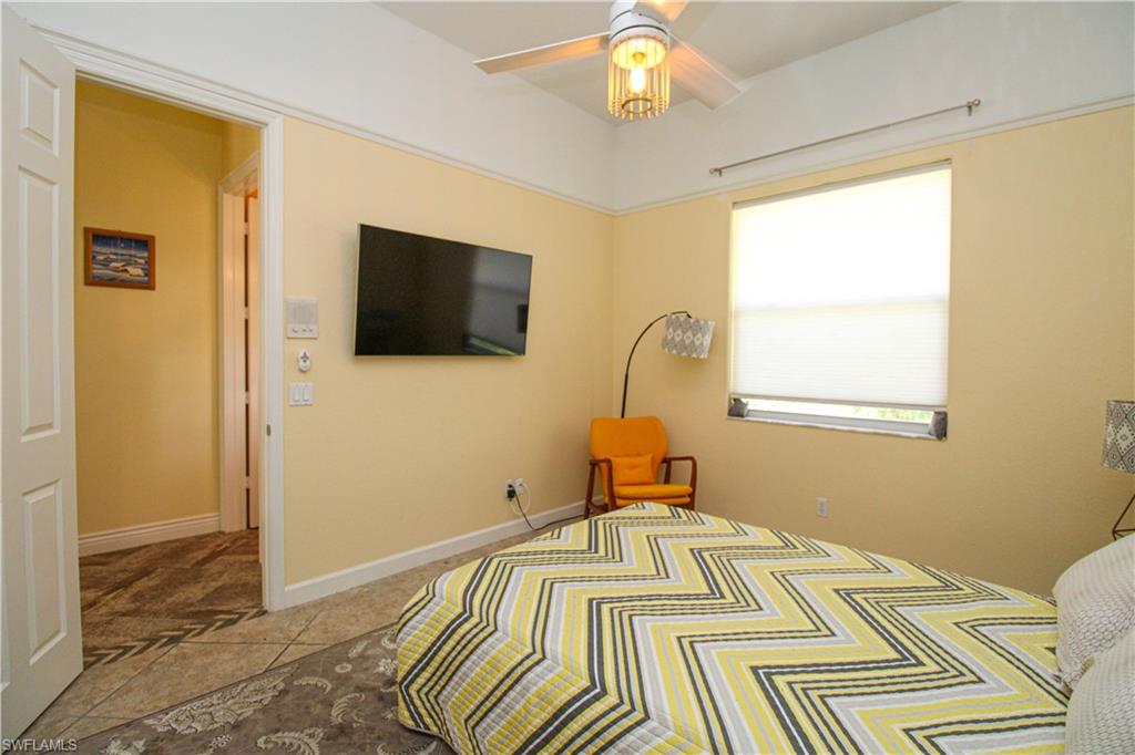 627 Soliel Drive Naples, FL 34110 - Photo 38 of 45 a bedroom with a bed and a flat screen tv