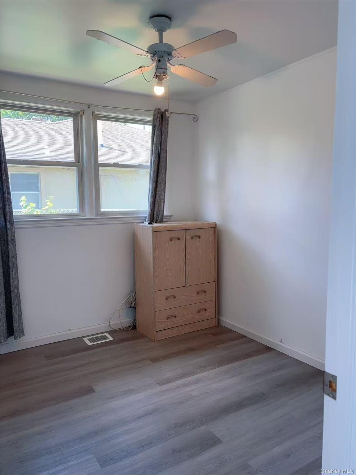 439 Newbridge Road East Meadow, NY 11554 - Photo 11 of 15 an empty room with wooden floor and windows
