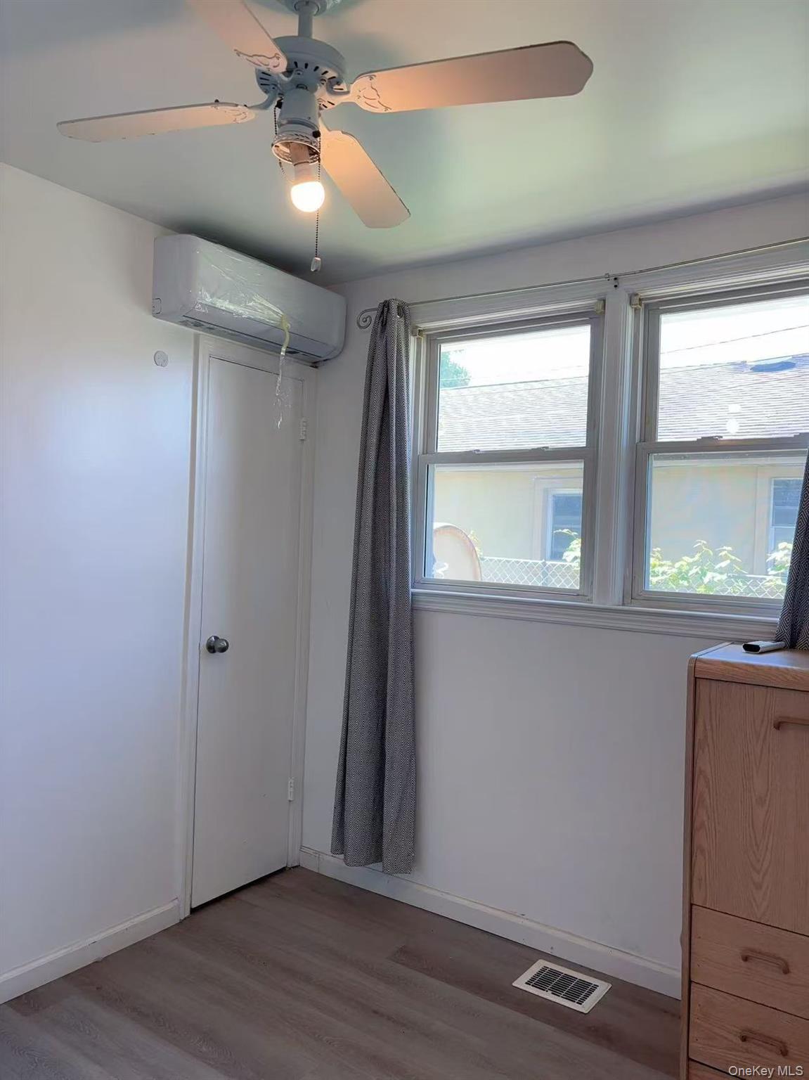 439 Newbridge Road East Meadow, NY 11554 - Photo 12 of 15 wooden floor in an empty room with a window