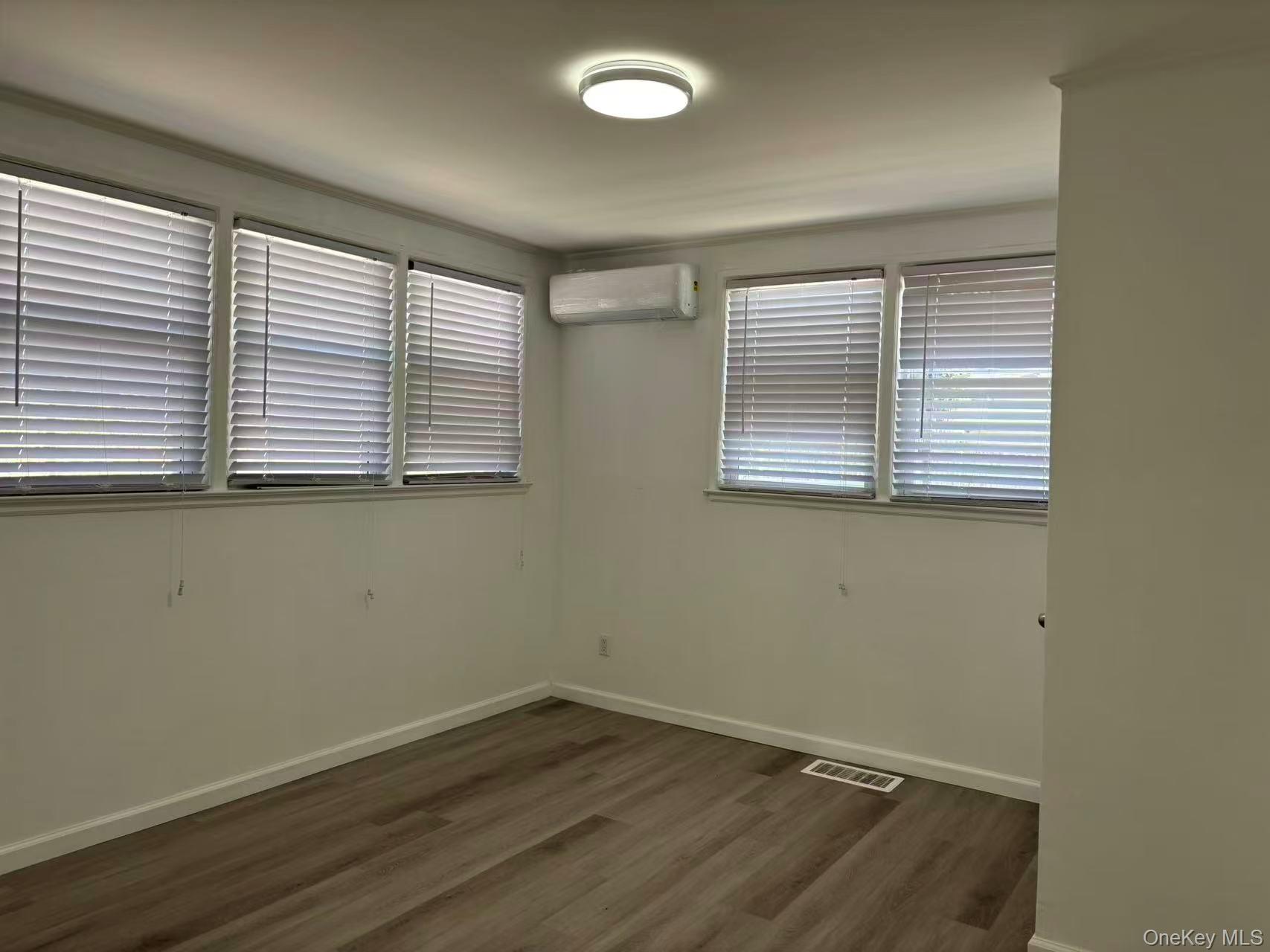439 Newbridge Road East Meadow, NY 11554 - Photo 5 of 15 an empty room with wooden floor and windows