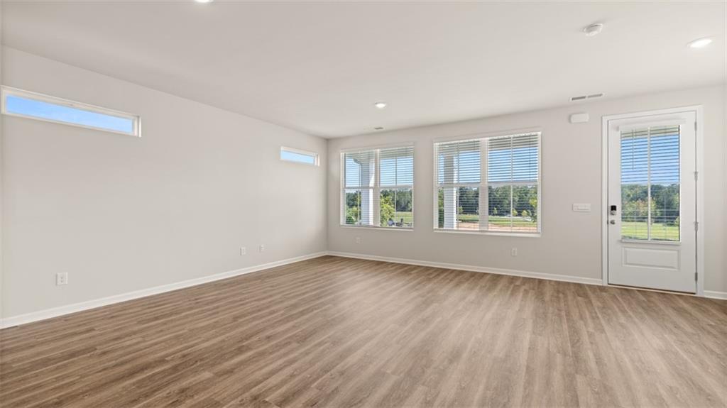 906 Stow Lane Monroe, GA 30655 - Photo 14 of 28 a view of an empty room with wooden floor and a window
