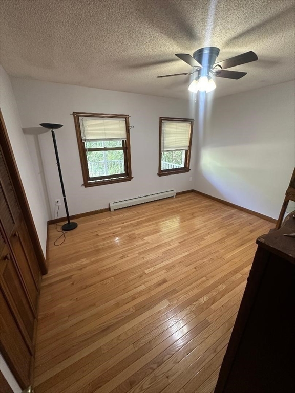99 Old Poor Farm Road Ware, MA 01082 - Photo 12 of 29 a view of an empty room with chandelier fan and wooden floor