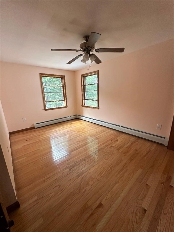 99 Old Poor Farm Road Ware, MA 01082 - Photo 17 of 29 an empty room with wooden floor chandelier fan and windows