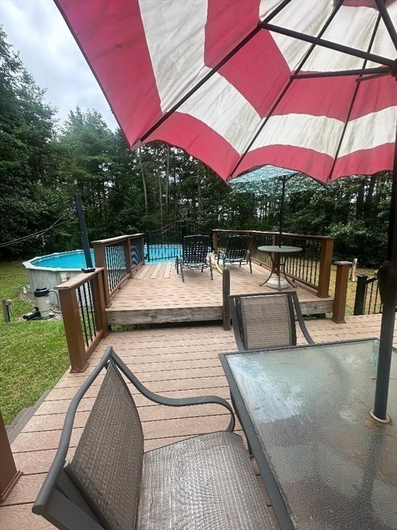 99 Old Poor Farm Road Ware, MA 01082 - Photo 7 of 29 a view of a patio with couches and table under an umbrella