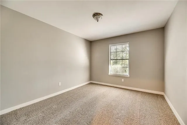 a view of a big room with windows and chandelier fan