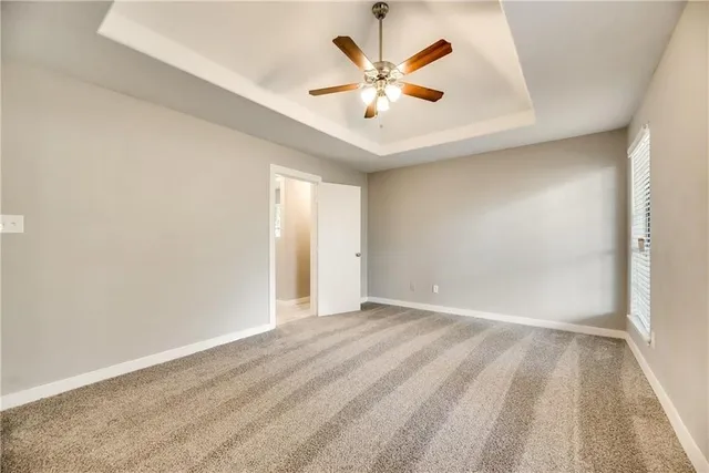 an empty room with a window and a ceiling fan