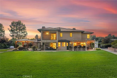 a view of a house with a big yard and sitting area