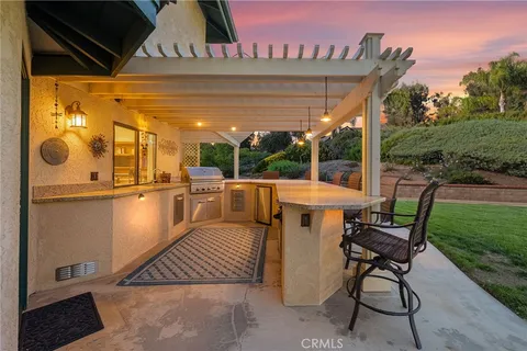 a view of a patio with table and chairs with wooden floor and fence