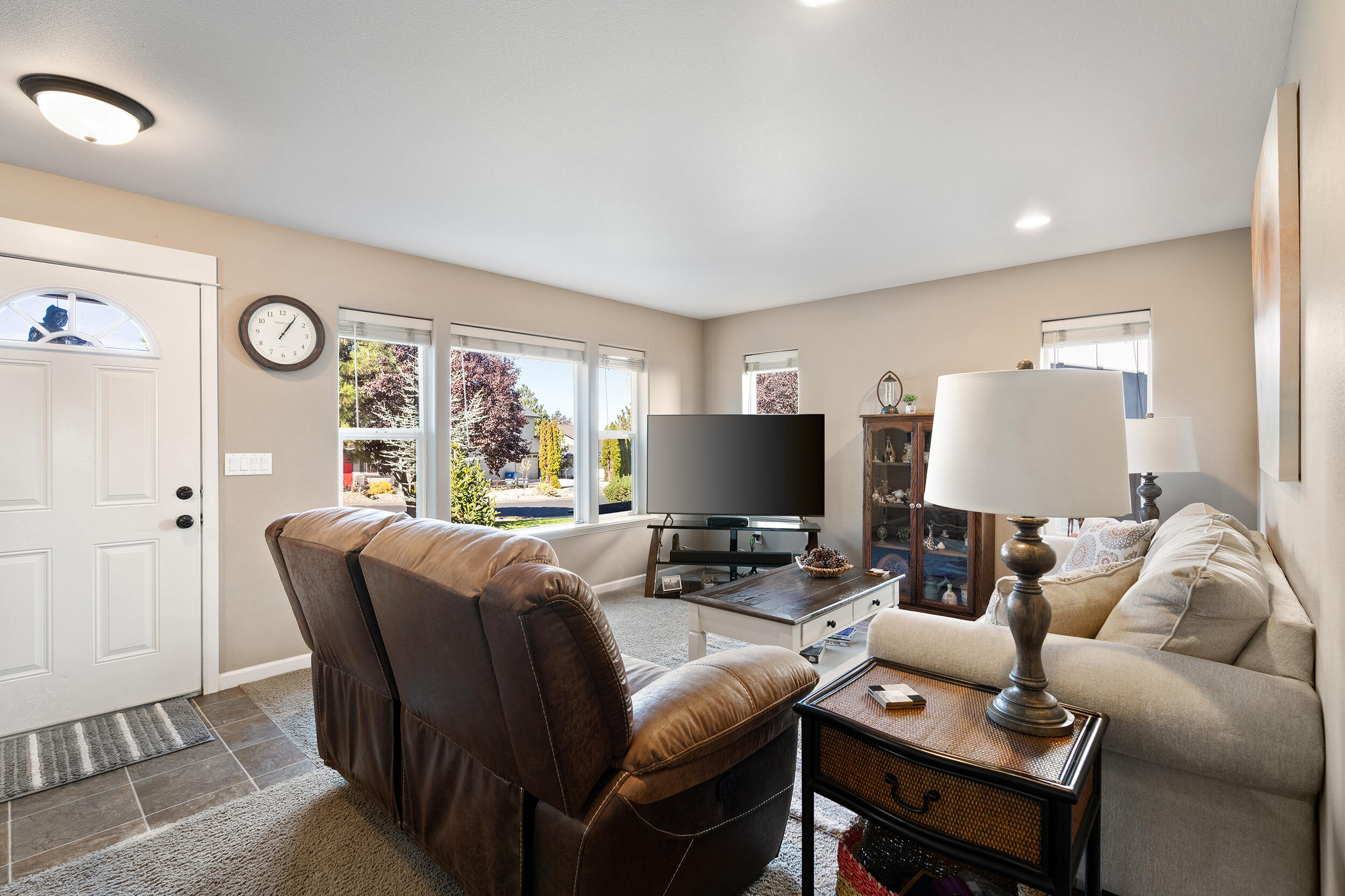 62906 Bilyeu Way Bend, OR 97701 - Photo 81 of 100 a living room with furniture a large window and a flat screen tv