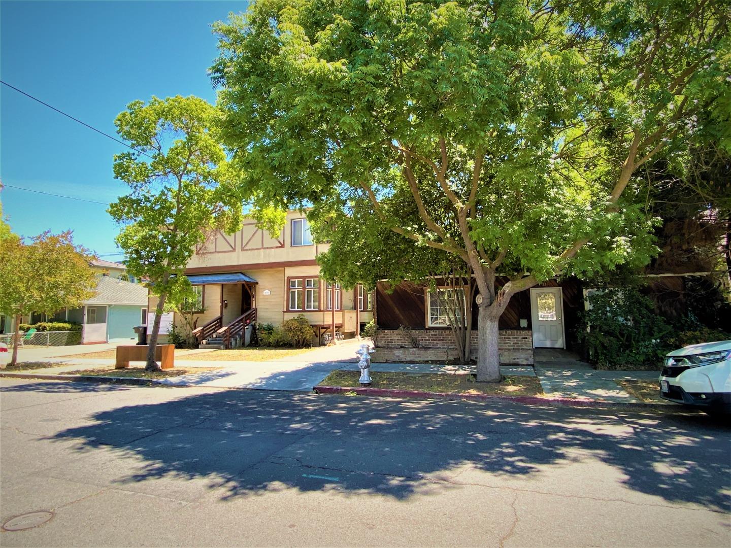 a front view of a house with a yard tree and outdoor seating