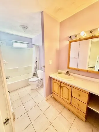 a bathroom with a double vanity sink toilet and a tub