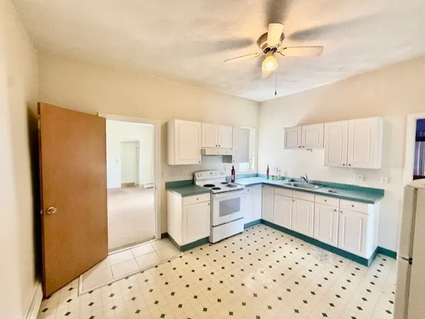 a kitchen with granite countertop appliances a sink and a refrigerator